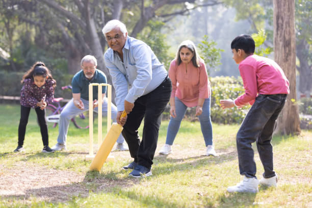 istock Family playing cricket in park 2151246703