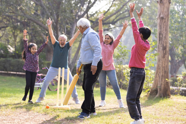 istock Family playing cricket in park 2151246719