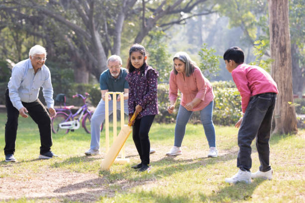 istock Family playing cricket in park 2151246720