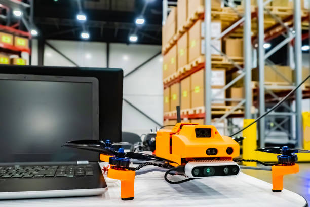 istock Office drone with a laptop. Warehouse equipment. Storage. Warehouse management. Drone inventory warehouse. Audit in stock. Scanning goods. Dron scans product information on the shelves. 2151247152