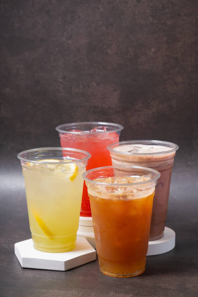 istock Four takeaway glasses of summer drinks with ice. Lemonade on dark background 2151248028