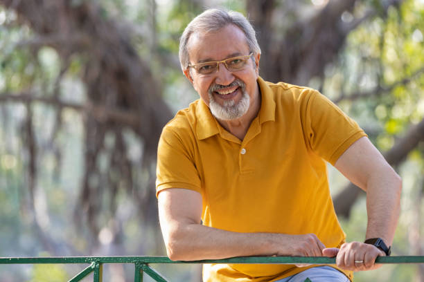 istock Happy senior man with arms crossed at park 2151248144