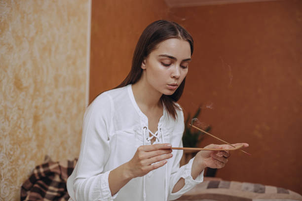 istock Woman with incense stick doing aromatherapy and relaxing at home 2151249007
