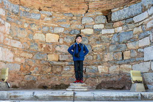 View of a child standing on a stage in Library of Celsus. Ephesus, Turkey.