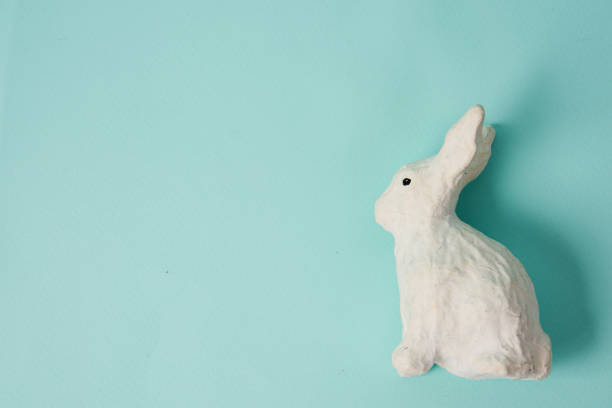 istock Festive white rabbit toy on a blue background with pastel colors Easter 2151252083