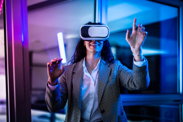 Young female entrepreneur with tablet working in virtual office. Woman touching virtual screen. Woman with VR  glasses working in office.