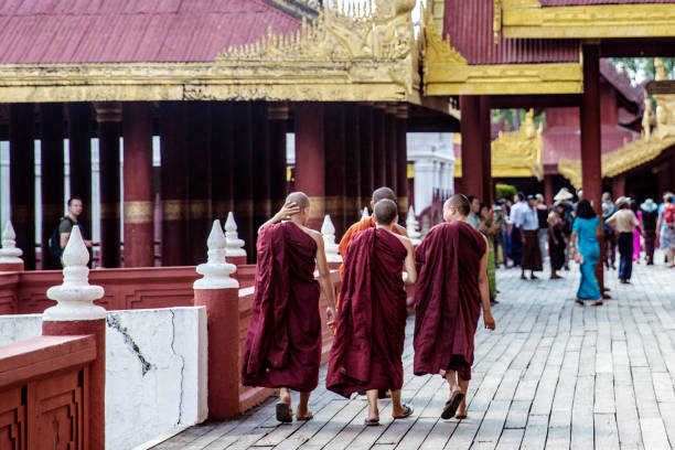 Mandalay, Myanmar - October 18, 2017: Young monks in Mandalay Palace study Buddhism, history, and traditional arts. They lead disciplined lives, adhering to strict schedules of meditation and learning. Their education emphasizes moral values, preparing them to become spiritual leaders. The palace provides a serene environment conducive to their growth as future custodians of Burmese cultural heritage.