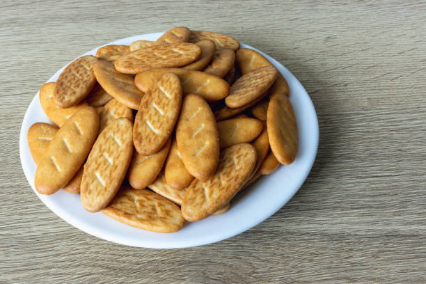 Salty crackers Senior Batonio in white plate on oak table top view