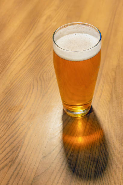 istock A glass of yellow beer with a cast shadow on the table 2151256480