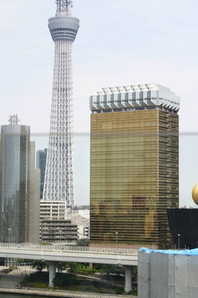 A photo of the Tokyo Skytree (only partially in frame) next to a gold and white building shaped like a beer mug in Asakusa