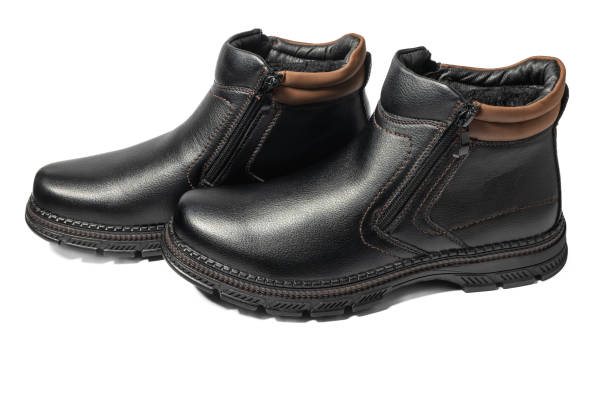 Pair of men's black winter boots on white background, isolated side view