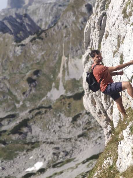 istock A black-haired man climbs a rock 2151257467