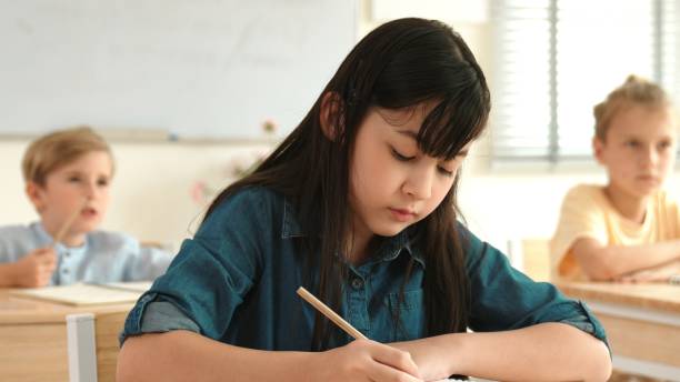 istock Girl writing answer in paper while focus on thinking during test. Pedagogy. 2151257754
