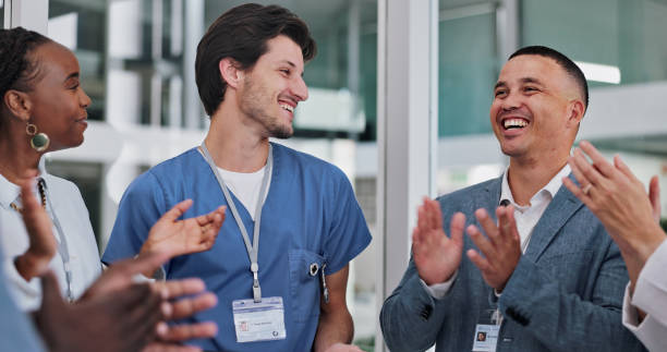 istock Doctors, group and celebration with applause for medical success, advice and support in teamwork or hospital solution. Healthcare staff, clapping and nurse with smile and talking for clinic results 2151258850