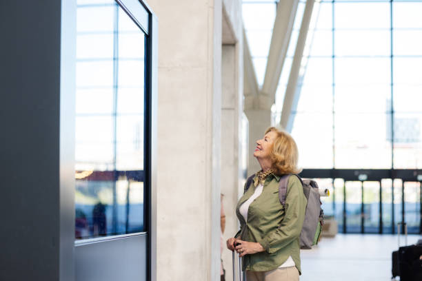 istock Senior woman looking at the departure board 2151260367