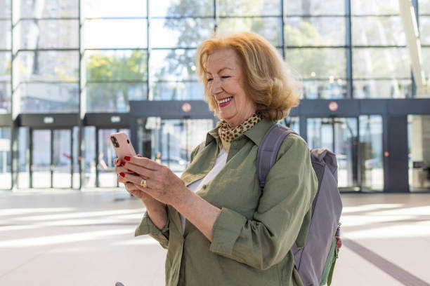 istock Senior woman with backpack using smart phone 2151260414