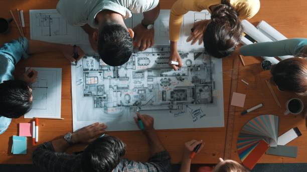 istock Top down view of engineer team writing at blueprint at meeting table. Symposium. 2151262716
