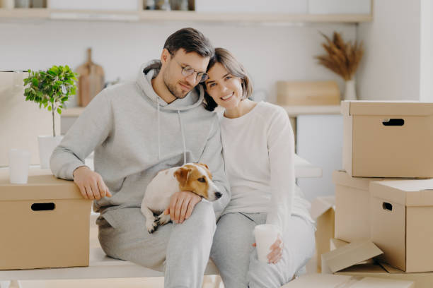 istock Relaxed couple with coffee and dog amidst move, sharing a serene moment. 2151263170