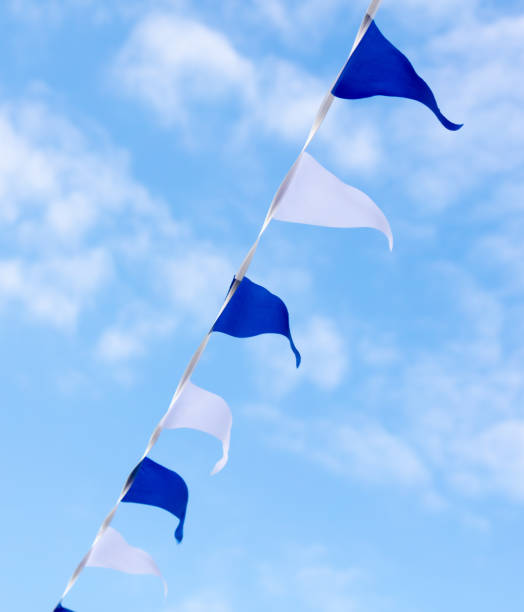 istock Festive blue white flags against the sky with clouds 2151265150