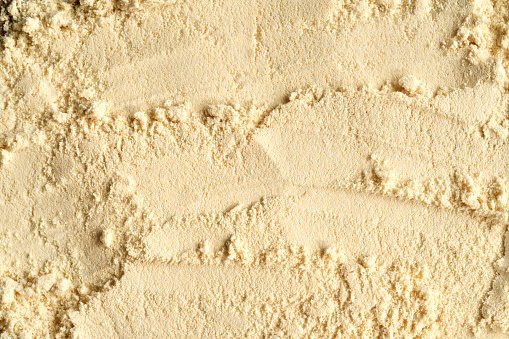 Background made of whey protein powder - healthy nutritional supplement, top view