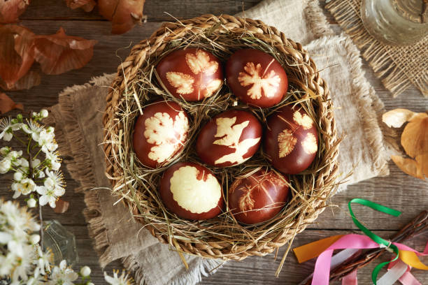 istock Brown Easter eggs dyed with onion peels in a wicker basket with spring flowers 2151266935
