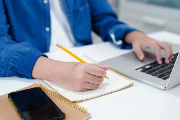 istock Asian teenage student write homework with laptop computer, learning university education concept. 2151268125
