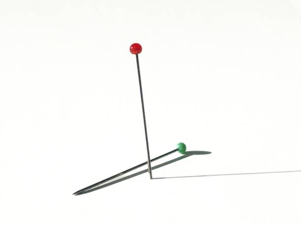 istock red pin, green pin. close-up pins and their shadows 2151277292