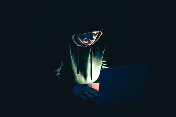 istock Cybersecurity, Man in a hood clothing using laptop at night. 2151278066