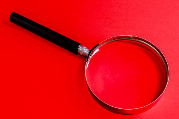 istock A magnifying glass is on a red background 2151279445
