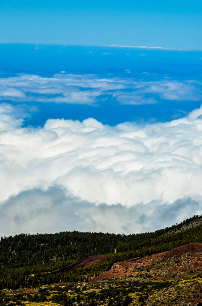 The sky is blue and the clouds are white. The clouds are low and fluffy, and the sky is clear