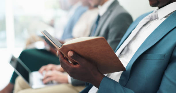 istock Businessman, hands and writing with book in row for notes, presentation or waiting room at the office. Closeup of man or employee filling notebook in line for schedule or attention at the workplace 2151281561