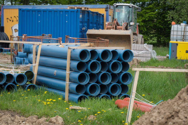 There are many blue pipes on a large construction site