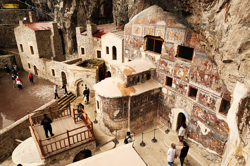 View from above onto the court, yard, courtyard of the Sumela, Sümela Monastery with visitors walking around and the Rock Church, completely covered in colorful frescos, Trabzon, Turkey 2022