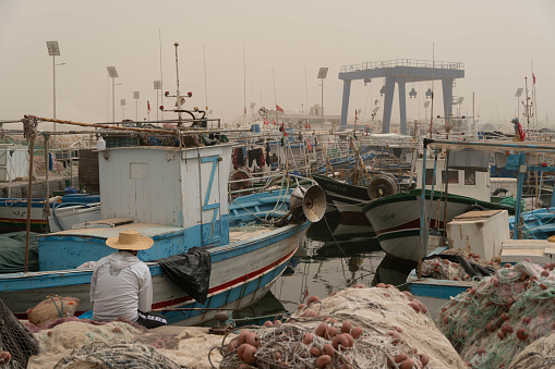 The port of Djerba after the sandstorm with the fishing and crab boats on the foreground.