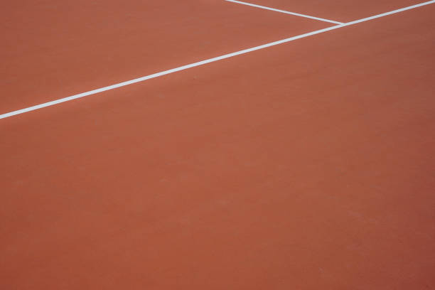 Diagonal white lines on an orange tennis court