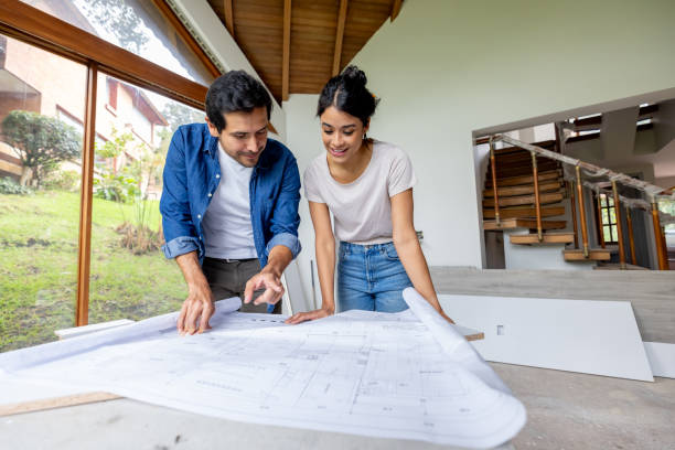 Couple looking at the blueprints while renovating their house