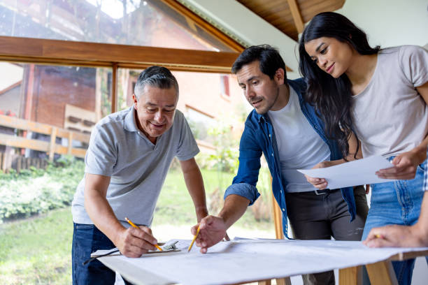 istock Couple remodeling their house and taking to the architect while looking at blueprints 2151288746