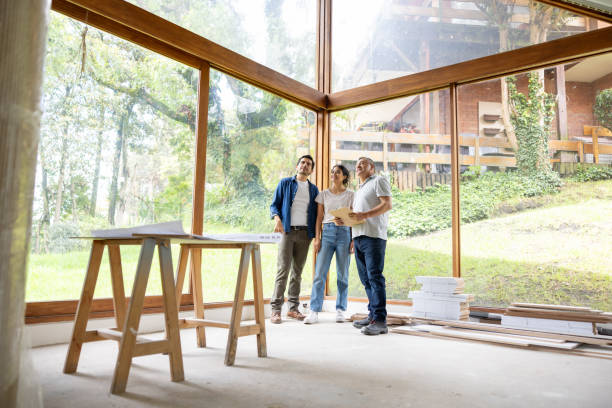 Happy couple remodeling their house and discussing ideas with the architect