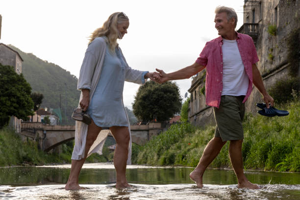 istock Mature couple walk across stream by medieval town 2151289581