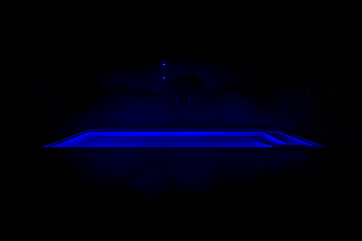 High contrast night scene swimming pool at meadow environment