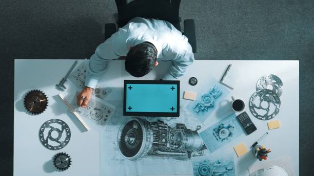 istock Top view of engineer writing in paper while looking at tablet. Alimentation. 2151290273