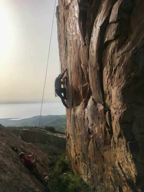 istock Mature man climbs cliff face with rope 2151294730