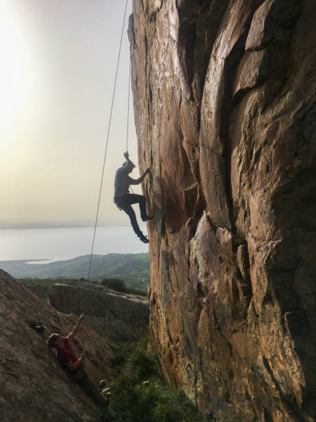 istock Mature man climbs cliff face with rope 2151294735