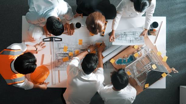 istock Top view of skilled engineer team talking while looking at plan. Alimentation. 2151297994