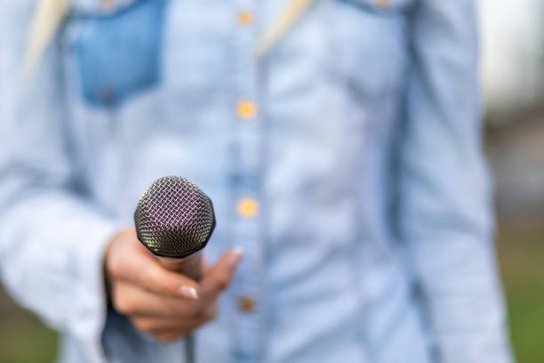 Female reporter journalist on the spot, holding microphone
