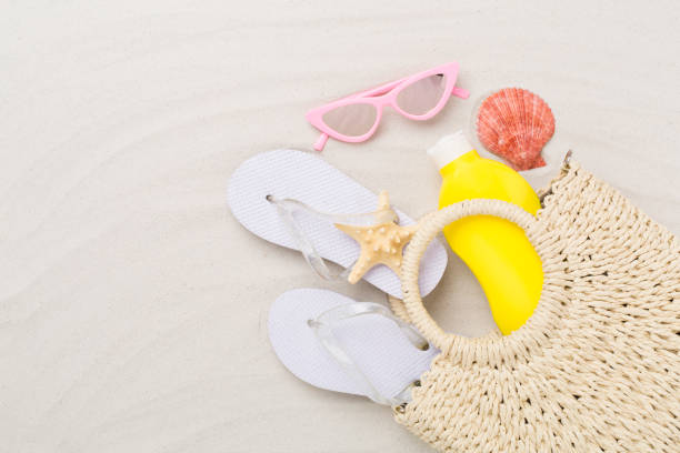 istock Straw bag with accessories on sand background, top view 2151299605