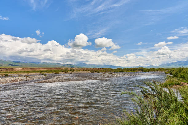 Landscape of the river valley, mountains and cumulus clouds above them. the valley of the Shalkodesu river in Kazakhstan