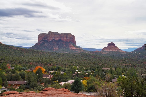 A man sits and admires the view of the red rock formations from the top of Doe Mountain in Sedona, Arizona.