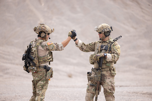 Two soldiers greeting together celebrating success