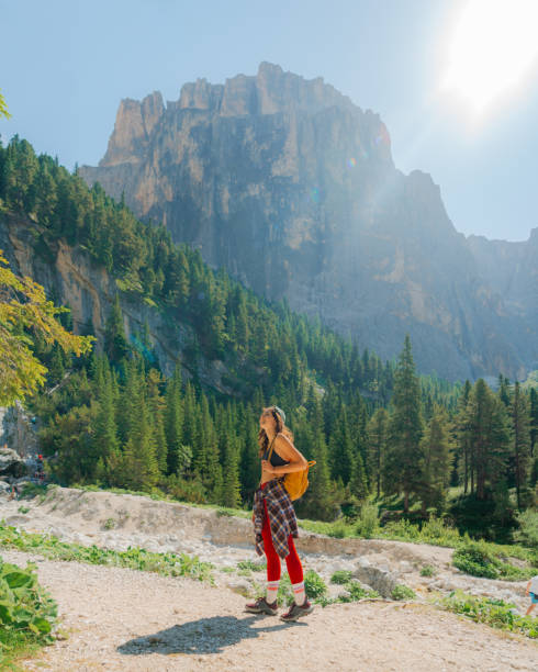 Determinted woman in vibrant sportswear hiking in Dolomites mountains in summer